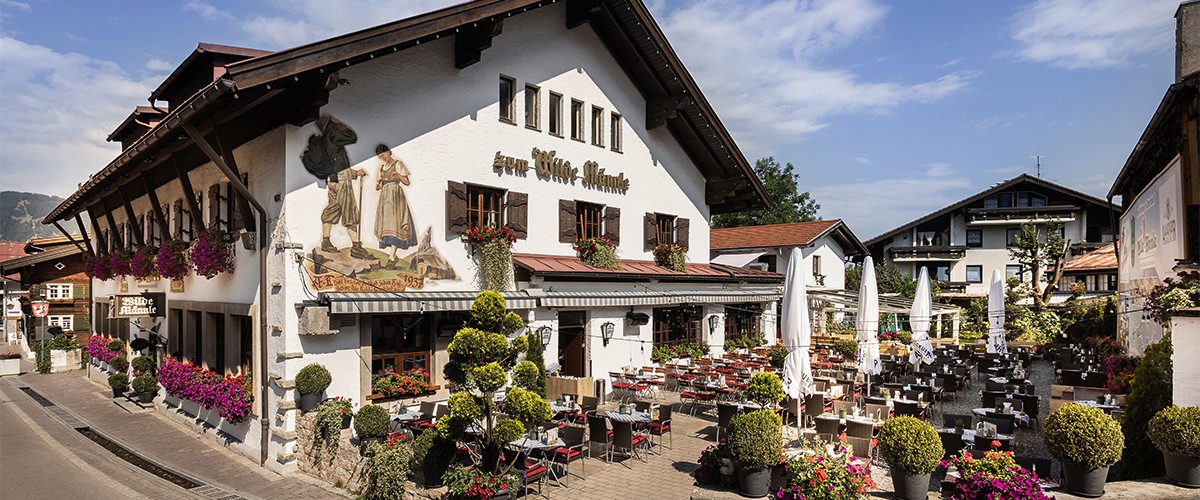 Eine traditionelle Gaststätte mit Holzmöbeln und dekorierten Tischen. Helle und warme Beleuchtung setzt Akzente.